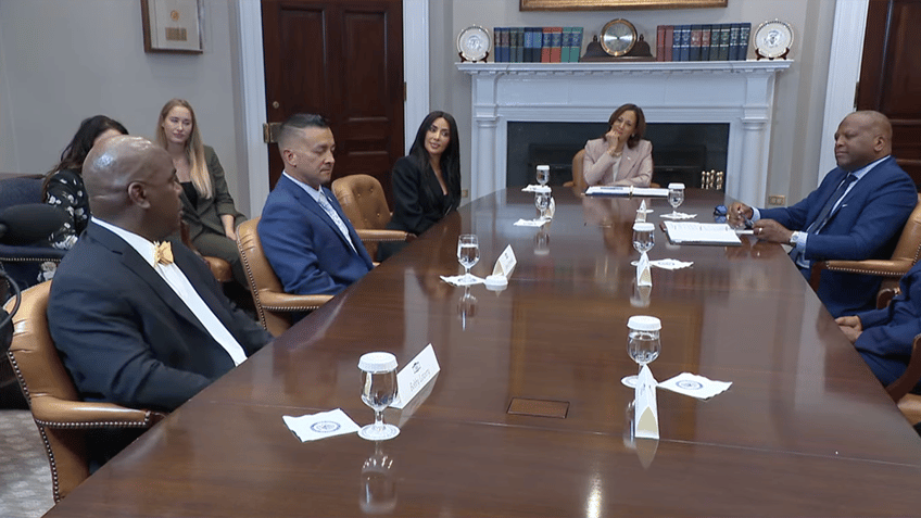 Kim Kardashian sits with Kamala Harris around a table with 4 pardon recipients