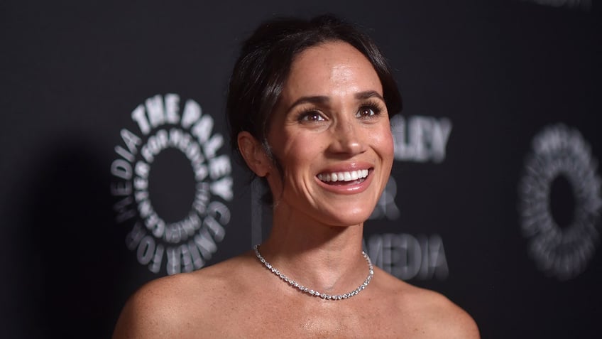 A close-up of Meghan Markle smiling with diamonds