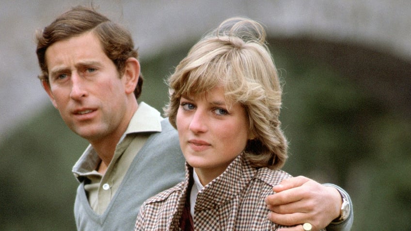 Prince Charles with his arm around a young Princess Diana