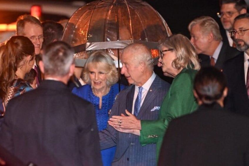 Britain's King Charles III (centre R) and Queen Camilla (centre L) are greeted upon their