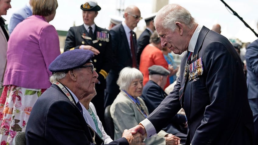 King Charles III shaking hands with a WWII veteran