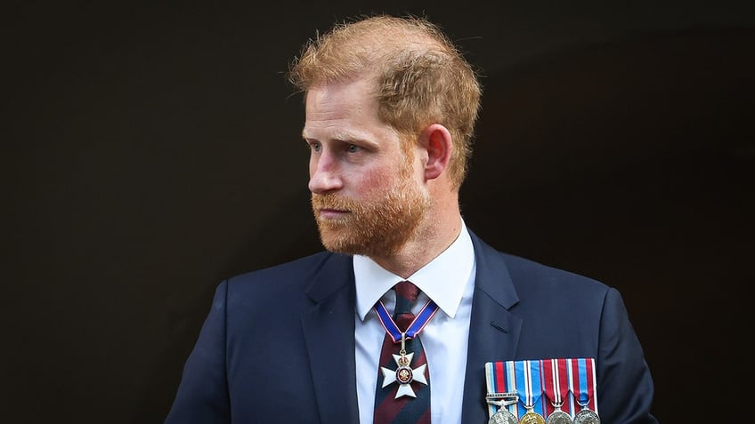 Prince Harry wearing a navy suit and medals