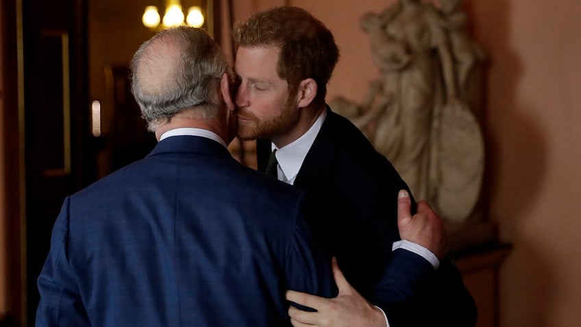 Prince Harry kissing his father King Charles on the cheek