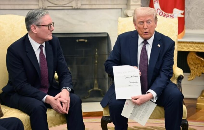 Donald Trump holds a letter from Britain's King Charles III during a bilateral meeting wit