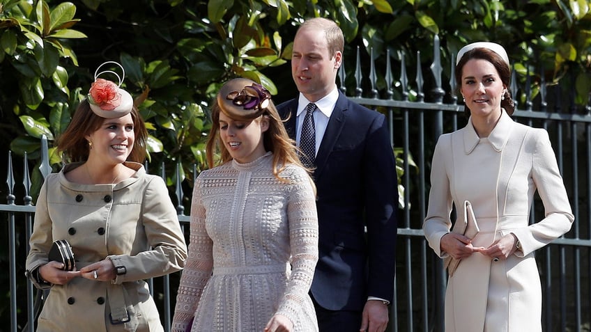 Princess Eugenie and Beatrice walking in front of Prince William and Kate Middleton outdoors by a fence.