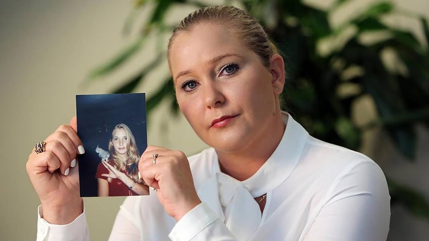 Virginia Giuffre wearing a white turtleneck and holding a younger photo of herself