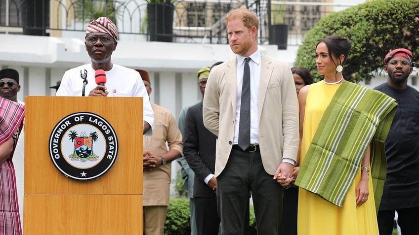 Prince Harry and Meghan Markle in formal wear standing next to each other outdoors