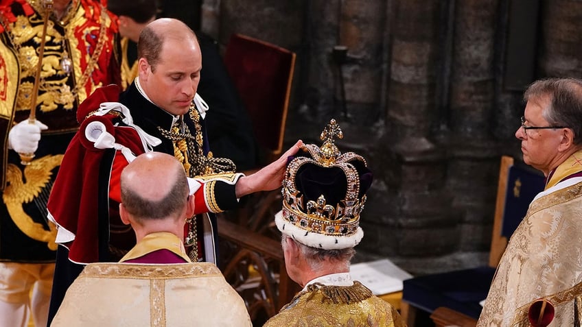 Prince William touching King Charles crown during the monarchs coronation.