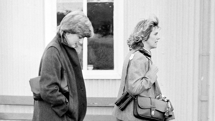 Princess Diana and Camilla walking near each other in a black and white photo.