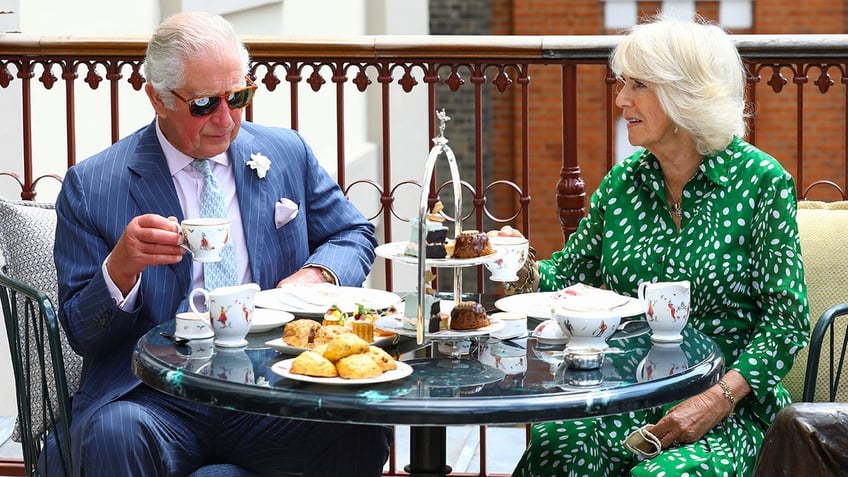 King Charles and Queen Camilla sitting together for afternoon tea.