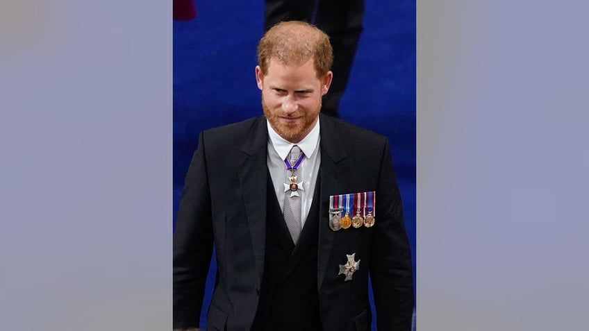 Prince Harry wearing a dark suit with medals