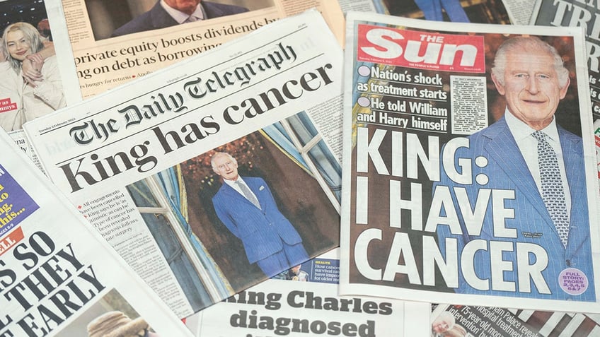 Newspapers announcing King Charles cancer diagnosis on top of each other