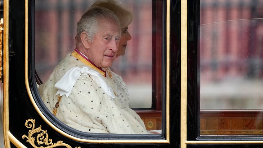 King Charles in a carriage wearing a white robe