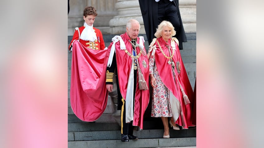 King Charles and Queen Camilla wearing red royal robes