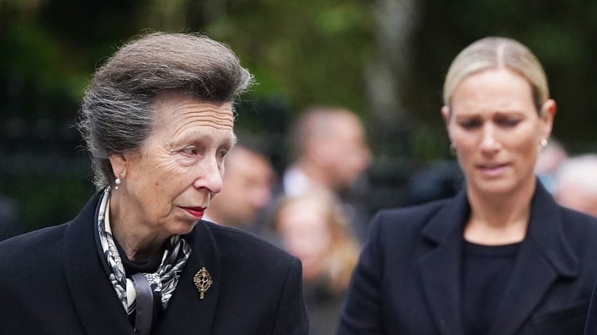 Princess Anne and Zara Tindall wearing black and looking somber.