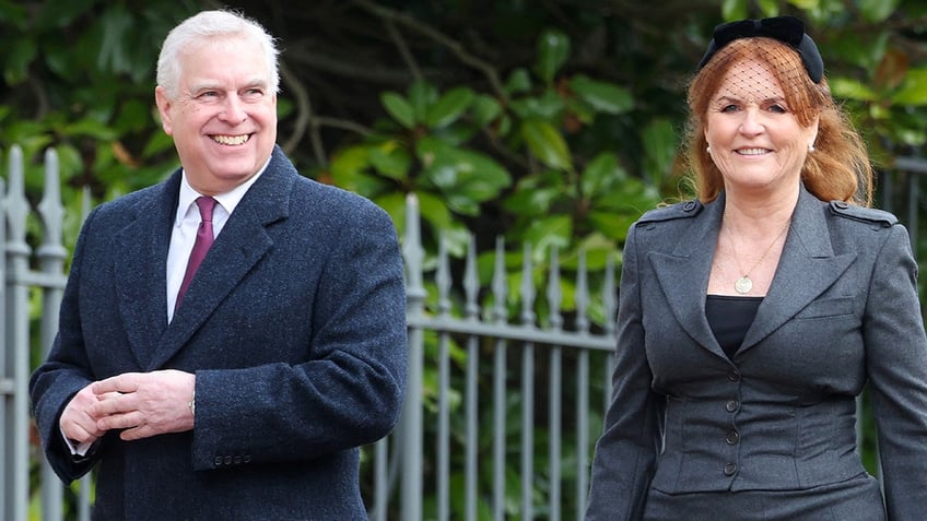 Prince Andrew smiling walking next to Sarah Ferguson in a grey suit