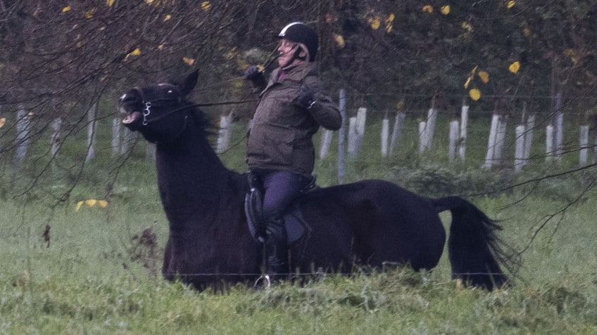 Prince Andrew looking worried as he rides a horse.