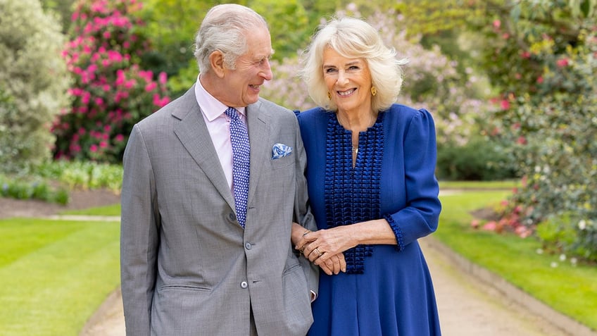 Britains King Charles III and Queen Camilla stand in Buckingham Palace Gardens