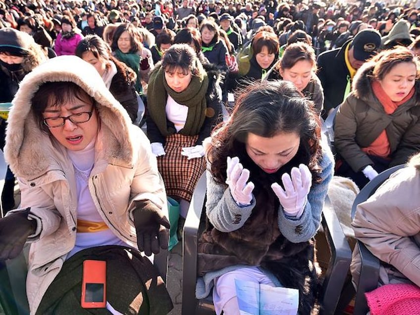 South Korean Christians pray during a New Year's service for the Korean peninsula's reunification and peace at the Imjingak peace park at the border city of Paju near the Demilitarized Zone (DMZ) dividing the two Koreas on January 1, 2015. North Korean leader Kim Jong-Un said on January 1 he was open to the "highest-level" talks with South Korea as he called for an improvement in strained cross-border relations. AFP PHOTO / JUNG YEON-JE (Photo credit should read JUNG YEON-JE/AFP via Getty Images)