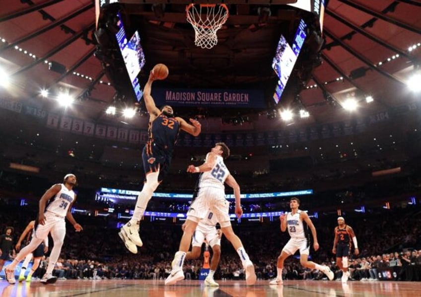 Karl-Anthony Towns of the New York Knicks soars for a dunk over Franz Wagner in the Knicks