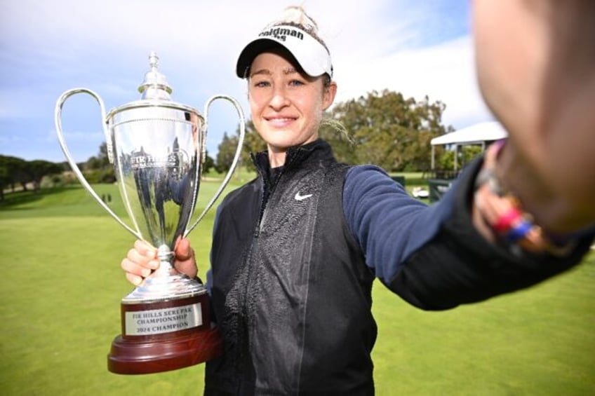 Nelly Korda imitates a "selfie" while holding her trophy from last week's LPGA event, a vi