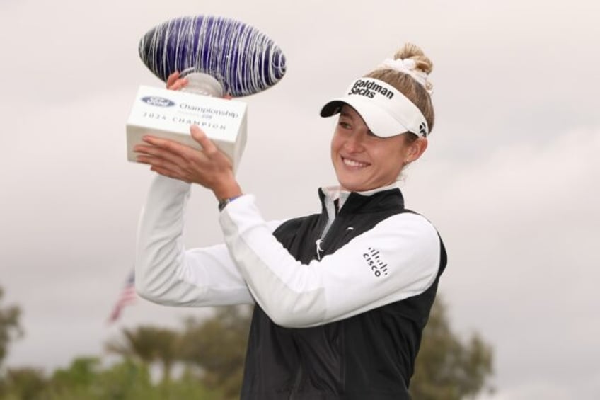 American Nelly Korda poses with the trophy after winning her third straight start on the L