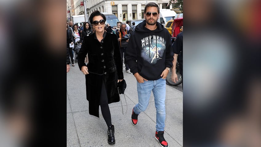 Kris Jenner in a black jacket walks alongside Scott Disick in a black sweatshirt and jeans in New York