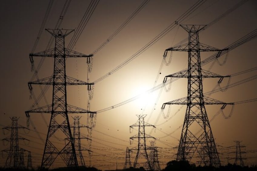 The sun sets behind overhead power lines in Kuwait City -- the electricity ministry said p