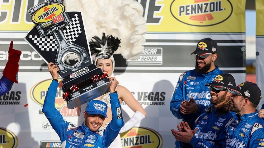 Kyle Larson raises the trophy