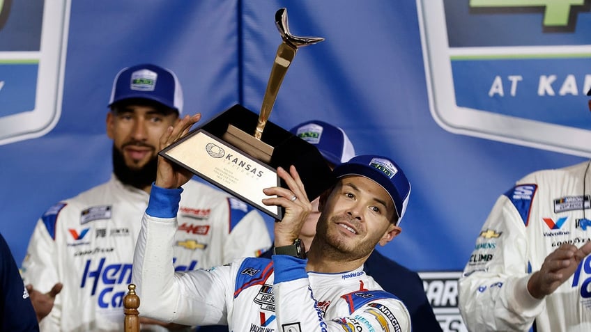 Kyle Larson holds the trophy