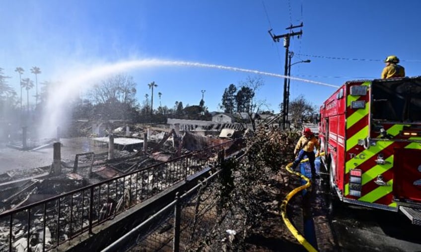 Firefighters water down smoky embers at the fire ravaged Sahag Mesrob Armenian Christian S