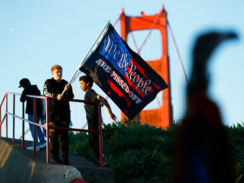 A young boy waves a flag as anti-vaxxers gather at the Golden Gate Bridge to protest manda