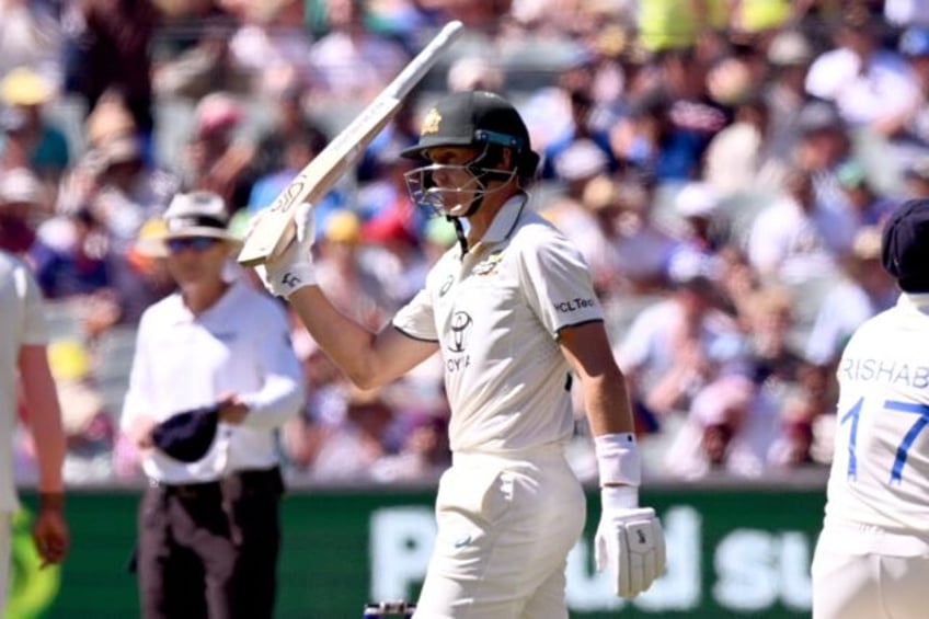 Australia's Marnus Labuschagne holds his bat aloft after bringing up his 50 in the second