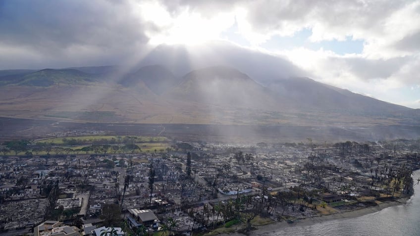 Sun beams through clouds over homes burned in the wildfires