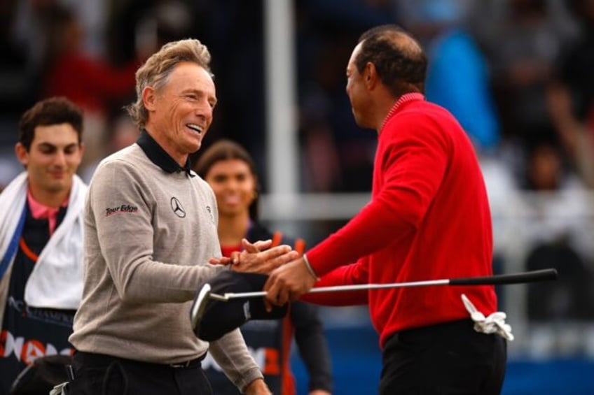 Tiger Woods and Bernhard Langer shake hands after Team Langer's victory over Team Woods in