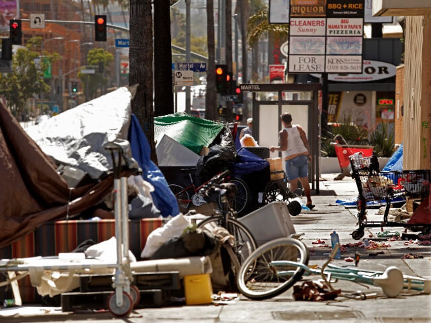 LOS ANGELES, CA - JUNE 1, 2022 - - A homeless woman stands in the middle of an encampment