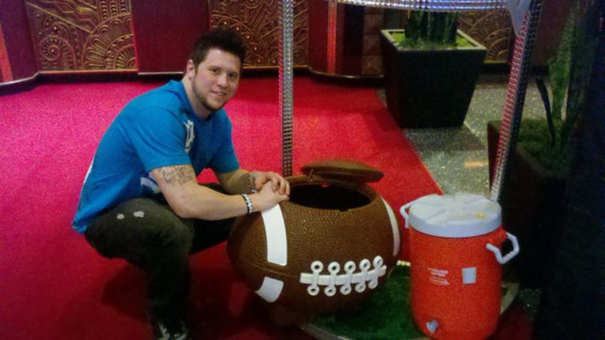 Michael Portaro sitting next to a football