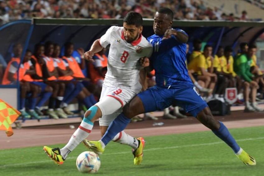 Tunisia midfielder Hamza Rafia (L) and Equatorial Guinea defender Saul Basilo fight for th