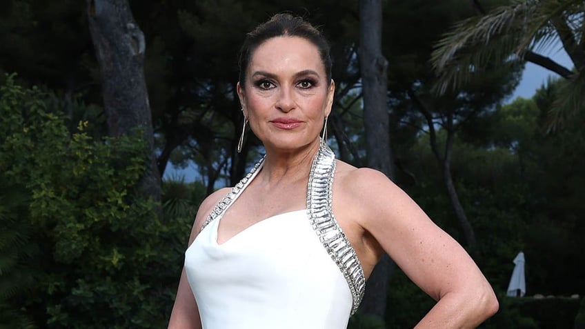 mariska hargitay posing in a white gown on a lawn 