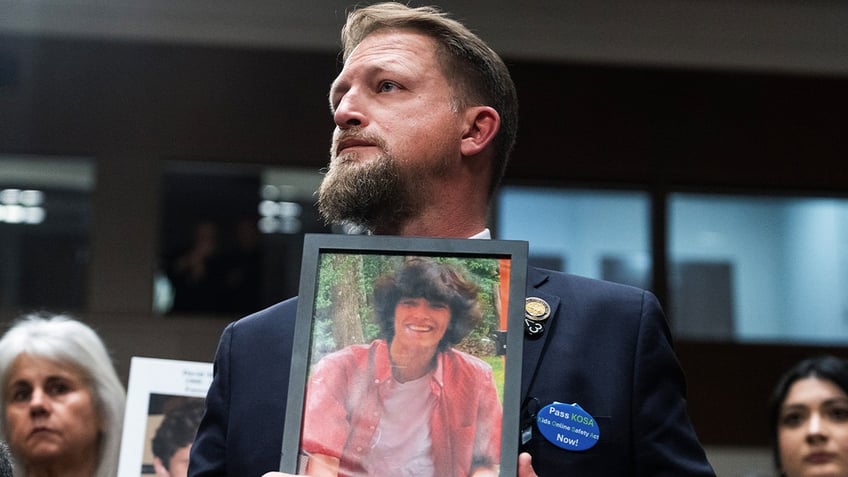 SC state Rep. Brandon Guffey holds a photo of his son, Gavin, who died by suicide in 2022