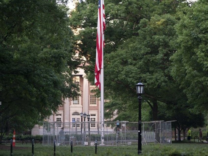 The American flag is surrounded by a temporary barrier at Polk Place at the University of