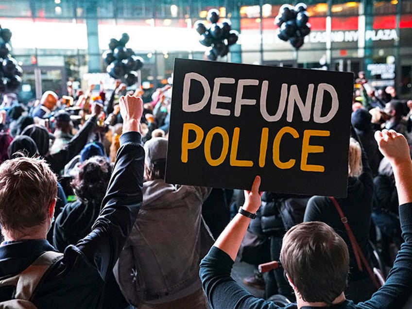 In this Oct. 14, 2020, file photo a protester holds a sign that reads "Defund Police" duri