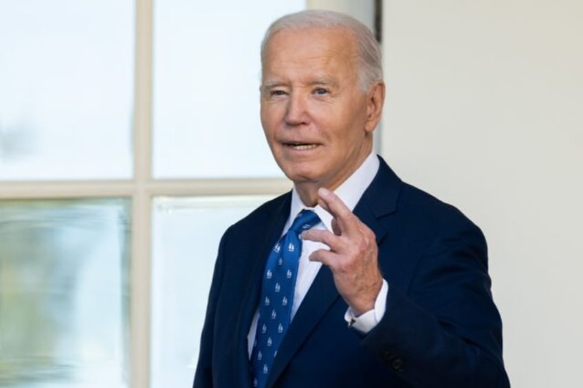 US President Joe Biden crosses his fingers as he answers a question about a Gaza ceasefire