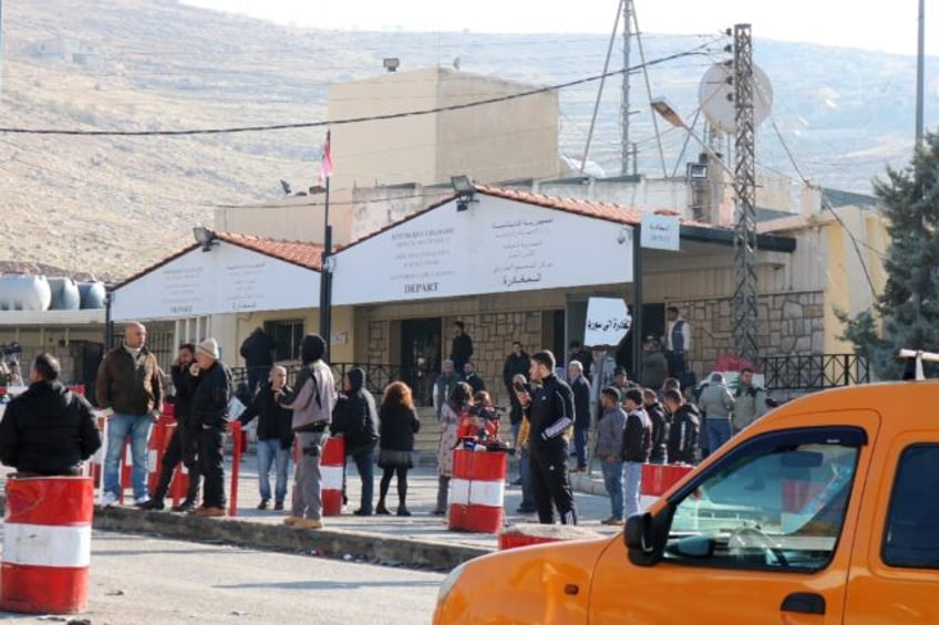 People wait at the entrance to the Masnaa eastern Lebanese border crossing after Syria imp