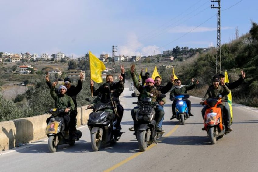 Residents of the southern Lebanese village of Kfar Kila parade with Hezbollah flags on the