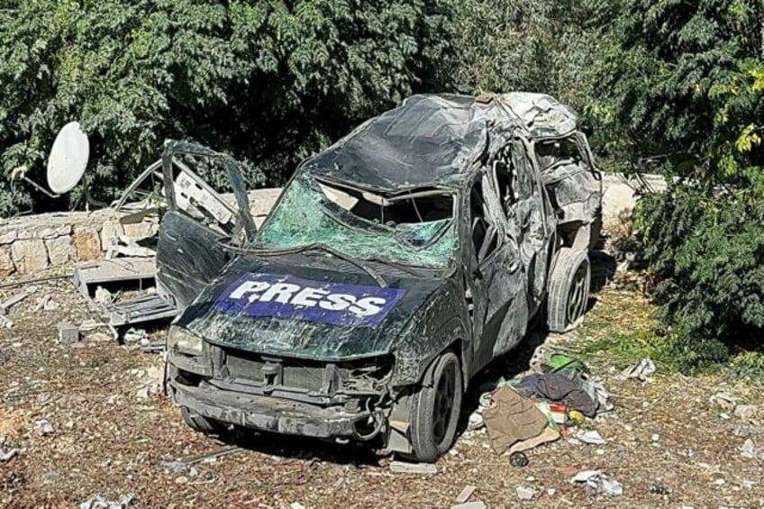 A car marked 'Press' is damaged at the site of a deadly Israeli air strike that targeted a