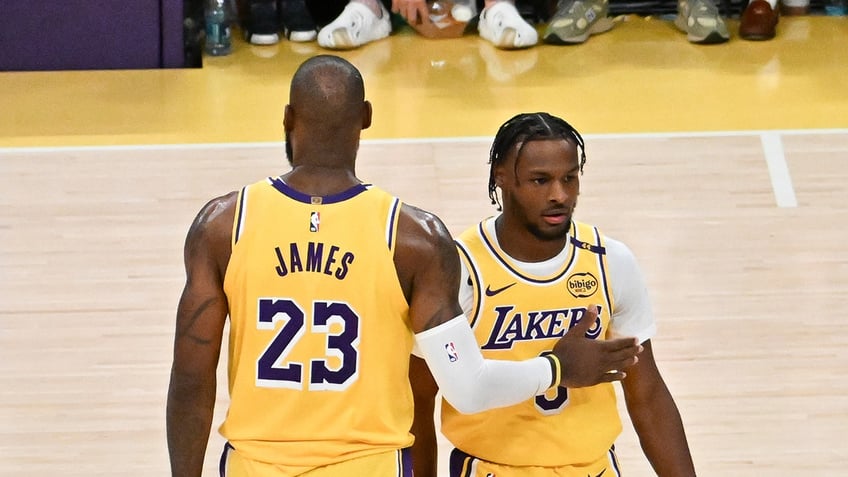 LeBron James #23 and Bronny James #9 of the Los Angeles Lakers on the court for the first time during the game against the Minnesota Timberwolves at Crypto.com Arena on Oct. 22, 2024 in Los Angeles, California.