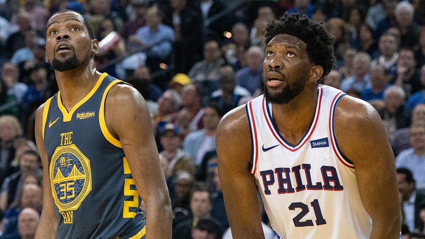 Joel Embiid and Kevin Durant on the court during a game