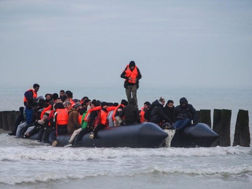 Migrants board a smuggler's inflatable dinghy as they attempt to cross the English Channel