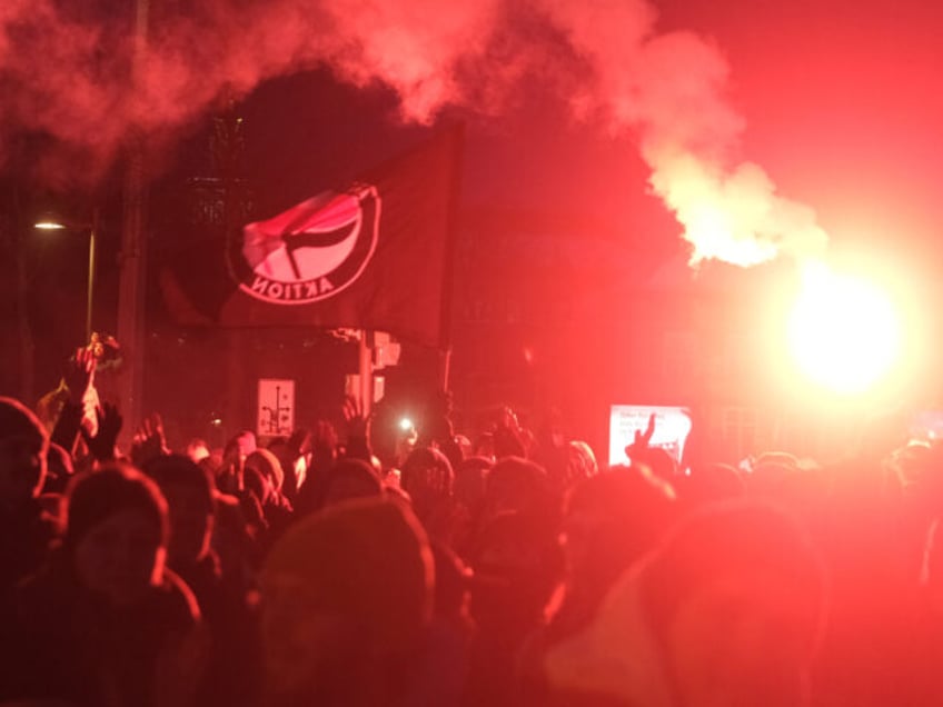 21 January 2024, Saxony, Leipzig: Participants in a rally gather on Johannisplatz while pyrotechnics are set off. According to initial police reports, more than ten thousand people gathered in Leipzig on Sunday for a demonstration against racism, fascism, the AfD and for democracy. According to a dpa reporter, the market …